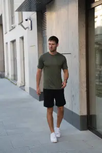 Mężczyzna w zielonym t-shircie sportowym merino podczas spaceru w mieście
